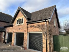 New black ash UPVC fascia and soffit with black square guttering on a triple garage